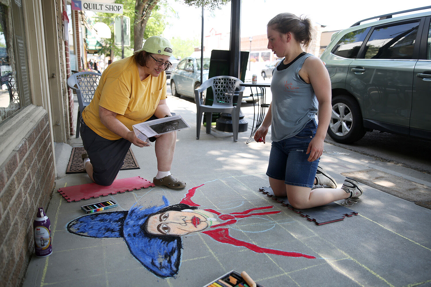 Vanessa Vogel, left, looks at the image that inspired the chalk art